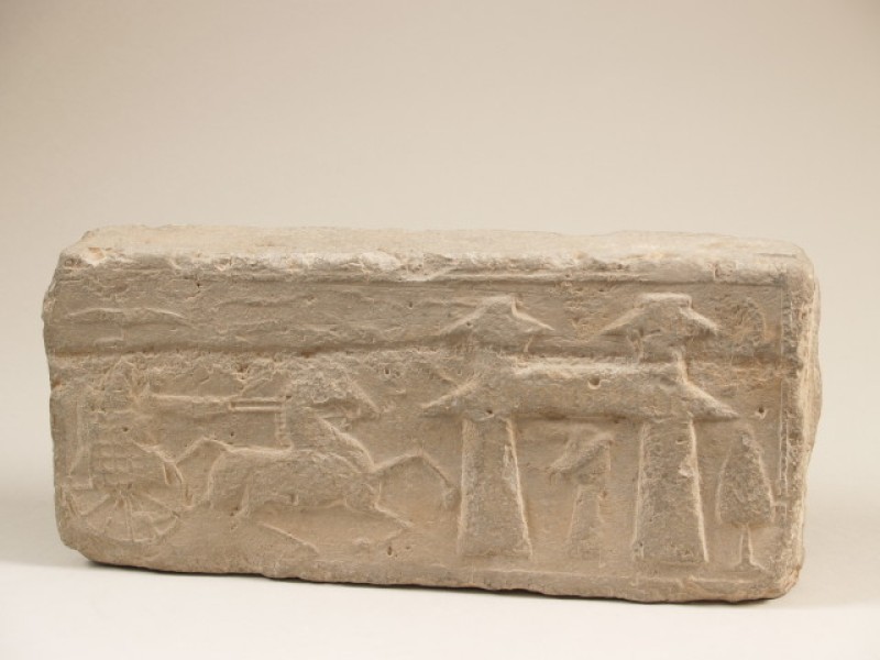 Fragment bouwkeramiek van grijs aardewerk met reliëfdecor van paard, wagen en figuur